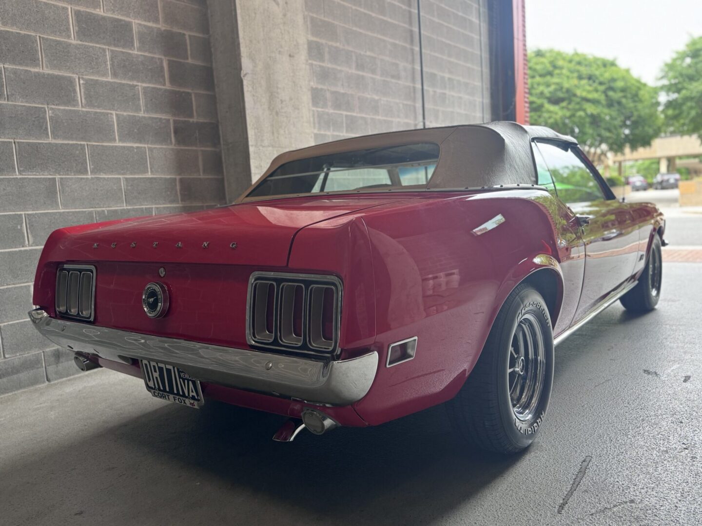 Red vintage Mustang convertible parked in garage