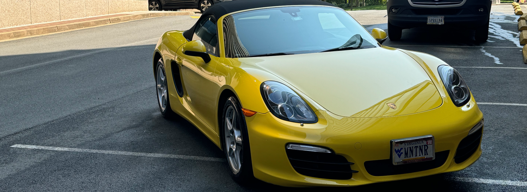 Yellow Porsche convertible parked in lot