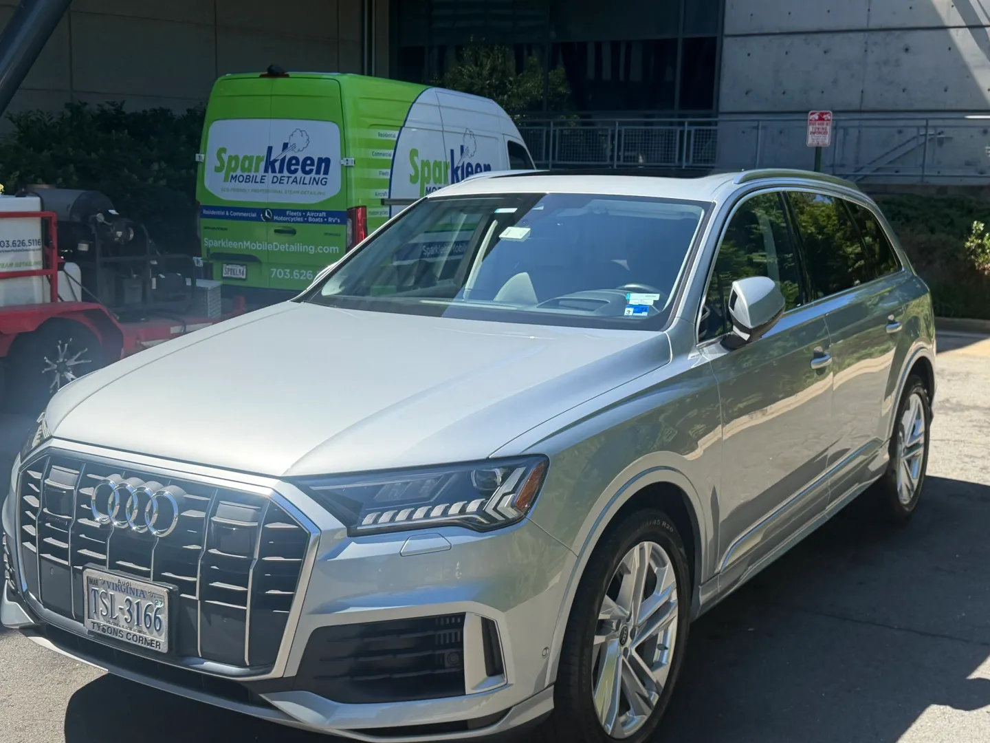 Silver Audi SUV parked near green van