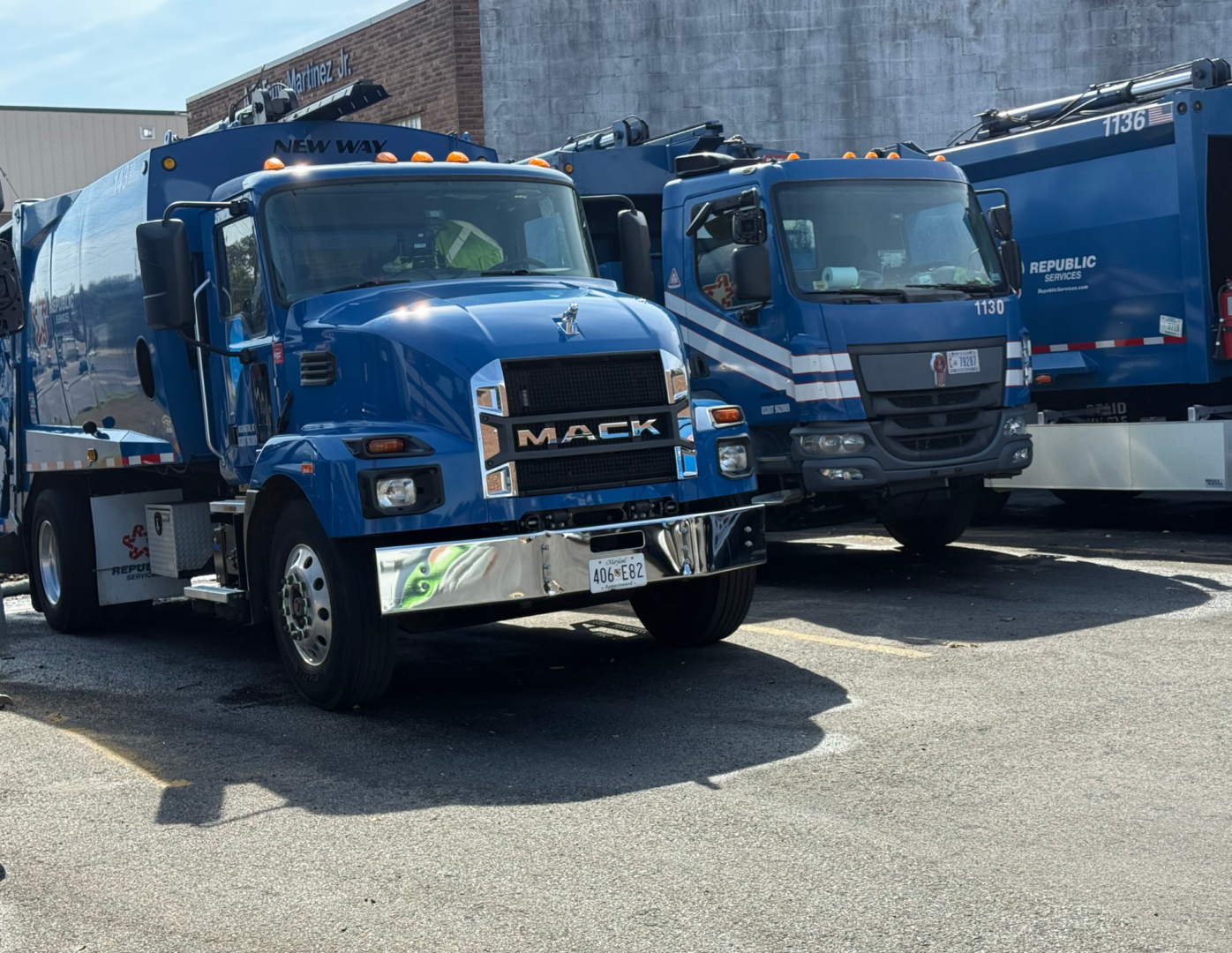 Blue Mack garbage trucks parked in lot